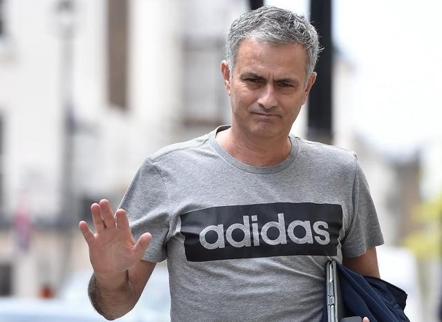 Jose Mourinho gestures as he walks towards his house in London, Britain.