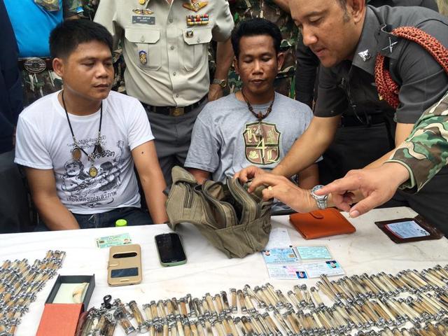A police officer, right, examines the belongings of two men arrested after attempting to remove tiger skin's and products from the "Tiger Temple," in Saiyok district in Kanchanaburi province, west of Bangkok, Thailand, Thursday, June 2, 2016. (AP) A police officer, right, examines the belongings of two men arrested after attempting to remove tiger skin's and products from the "Tiger Temple," in Saiyok district in Kanchanaburi province, west of Bangkok, Thailand, Thursday, June 2, 2016. (AP)
