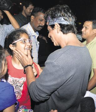 Shah Rukh Khan talks to a fan outside the restaurant. (HT photo)