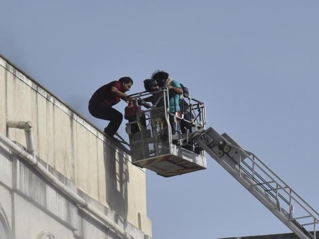 Three people were rescued from the burning building by fire brigade officials (top) as the efforts to douse the fire continued for hours. (KunaL Patil) Three people were rescued from the burning building by fire brigade officials (top) as the efforts to douse the fire continued for hours. (KunaL Patil)