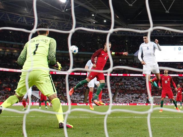 England's defender Chris Smalling (right) heads the ball to score during the friendly football match between England and Portugal at Wembley stadium in London.(AFP Photo)