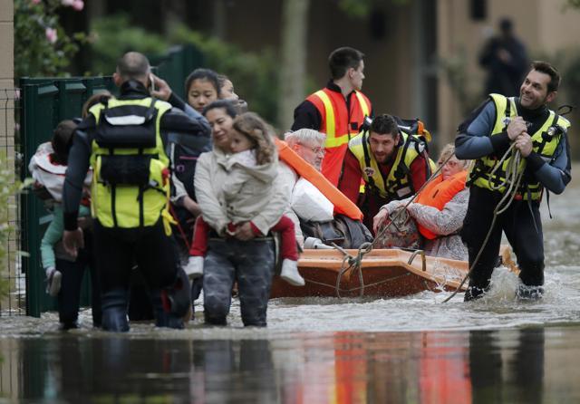 French firefighters on a small boat evacuate residents from a flooded area in Longjumeau, southern Paris. (REUTERS)