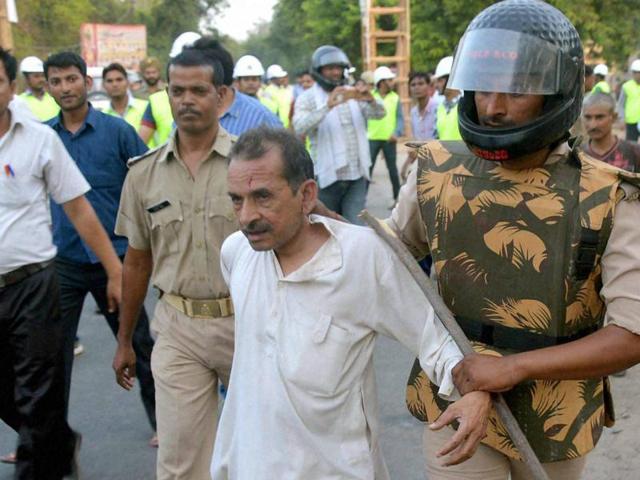 Policemen with a squatter in Mathura on Thursday. (PTI Photo) Policemen with a squatter in Mathura on Thursday. (PTI Photo)