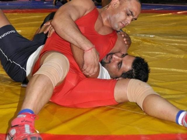 Wrestler Vinod Kumar (in red) tackles with another wrestler at a gym in Melbourne, Australia.