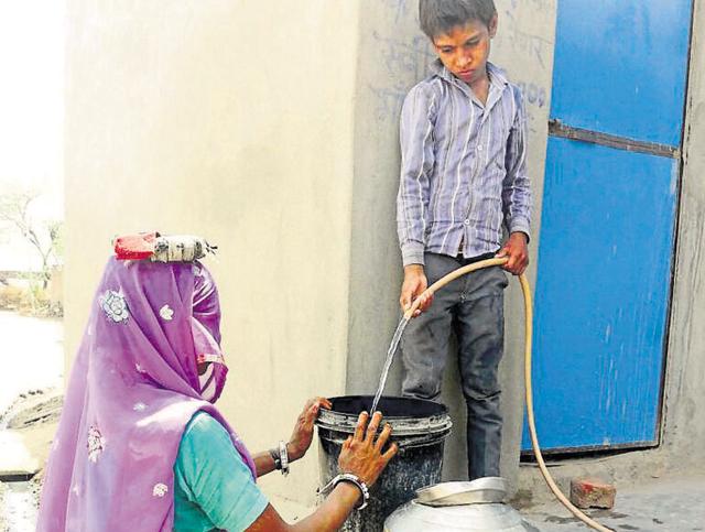 A boy fills water from a new water connection in Gudha Khurd village.(HT Photo)