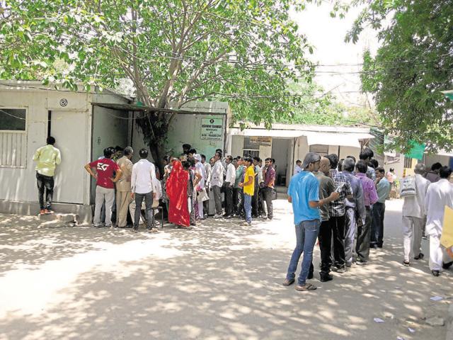 People wait in queues to get e-stamp papers from a vendor who operates from a shed under a tree at the district court, on Friday. (HT Photo) People wait in queues to get e-stamp papers from a vendor who operates from a shed under a tree at the district court, on Friday. (HT Photo)