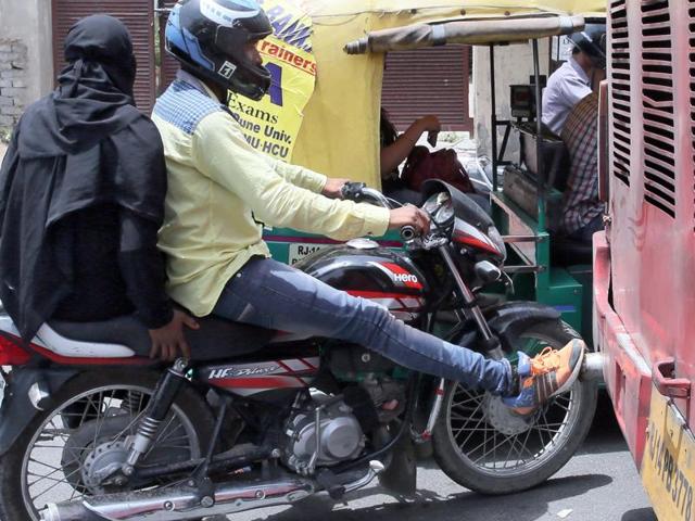 A bike rider presses his foot on the silencer of a low floor AC bus infamous in the city for bellowing dense fumes at a traffic stop. (Himanshu Vyas/HT Photo) A bike rider presses his foot on the silencer of a low floor AC bus infamous in the city for bellowing dense fumes at a traffic stop. (Himanshu Vyas/HT Photo)