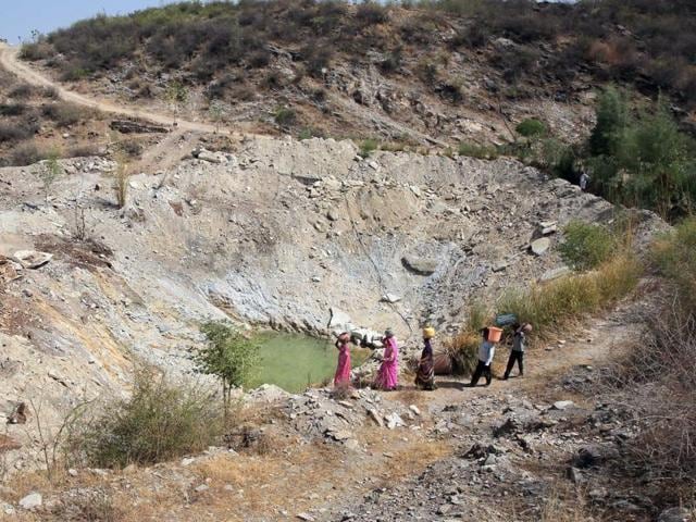 Villagers head towards a water hole atop a hill whose groundwater level has risen due to water harvesting at Pipalantri village in Rajsamand district, Rajasthan. (Himanshu Vyas/HT Photo) Villagers head towards a water hole atop a hill whose groundwater level has risen due to water harvesting at Pipalantri village in Rajsamand district, Rajasthan. (Himanshu Vyas/HT Photo)