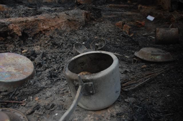 Hundreds of burnt cylinders and utensils litter the ground while foodgrains are scattered askew. (Antram/HT Photo)