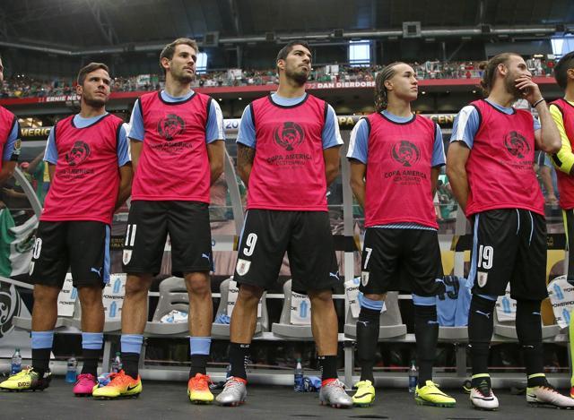 An injured Uruguay forward Luis Suarez (9) stands on the sideline with teammates Alvaro Gonzalez (left) Cristhian Stuani (11), Diego Laxalt (7) and Gaston Silva (19) prior to a Copa America group C football match against Mexico. (AP Photo)
