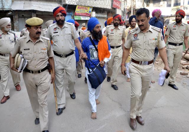 Police personnel taking Sikh radical activists, who were distributing the T-shirts having pictures of Bhindranwale, into custody in Amritsar on Monday. (Sameer Sehgal/HT Photo)
