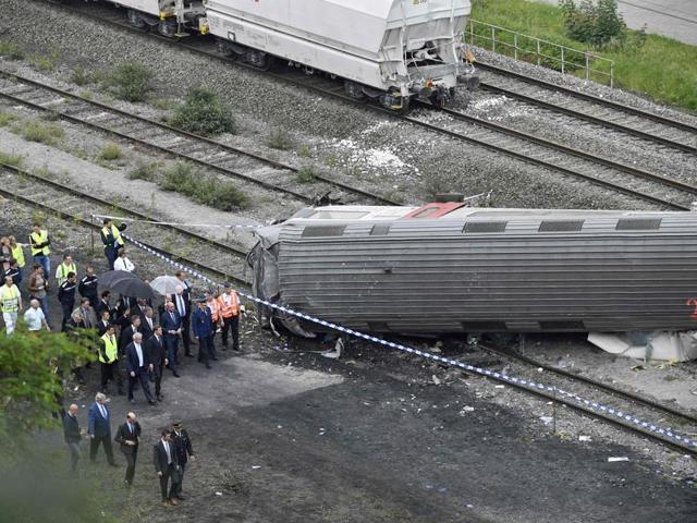 King Philippe of Belgium (C) and Belgian Prime Minister Charles Michel (C, right) visit the scene of a train collision between a freight train and a passengers train on the line between Liege and Namur. (AFP) King Philippe of Belgium (C) and Belgian Prime Minister Charles Michel (C, right) visit the scene of a train collision between a freight train and a passengers train on the line between Liege and Namur. (AFP)
