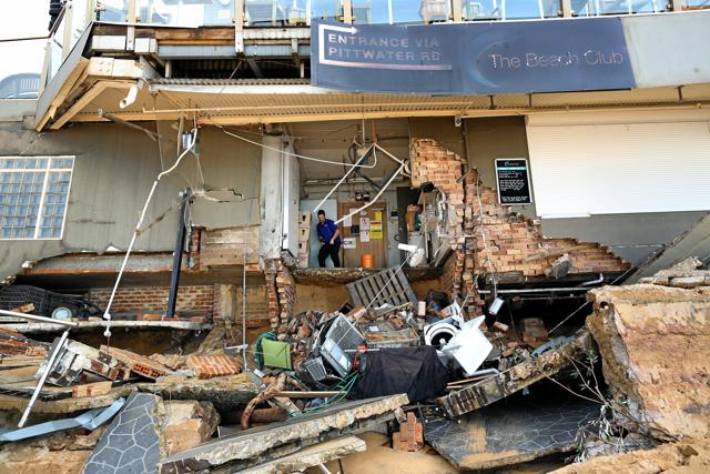 A man stands inside an area of The Beach Club after it was damaged by severe weather, which brought strong winds and heavy rain to the east coast of Australia, at Collaroy beach in Sydney. (Reuters) A man stands inside an area of The Beach Club after it was damaged by severe weather, which brought strong winds and heavy rain to the east coast of Australia, at Collaroy beach in Sydney. (Reuters)