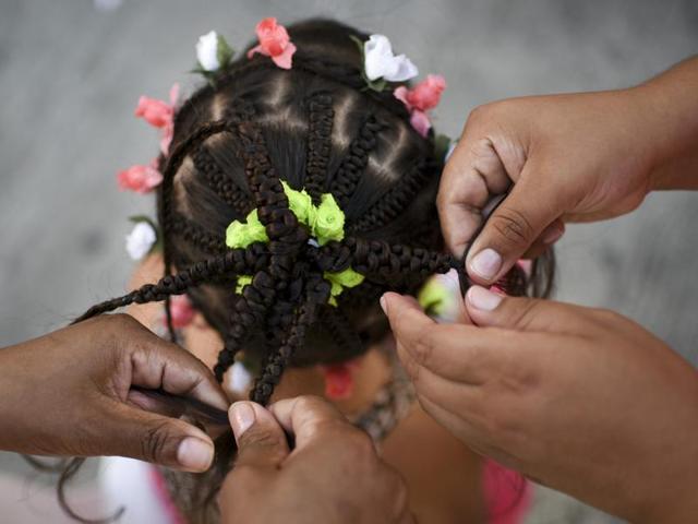 The contest seeks to revive African customs, identity and culture in Colombia.  A girl gets a hairstyle during the contest. Intricate braidwork, bright colours and bold designs are the hallmark of this style of hairdressing. (AFP) 