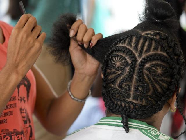 Slavery was finally abolished in Colombia in 1851. However, many were still mistreated and forced to let go their identity like braiding. A man gets a hairstyle during the contest. (AFP) 