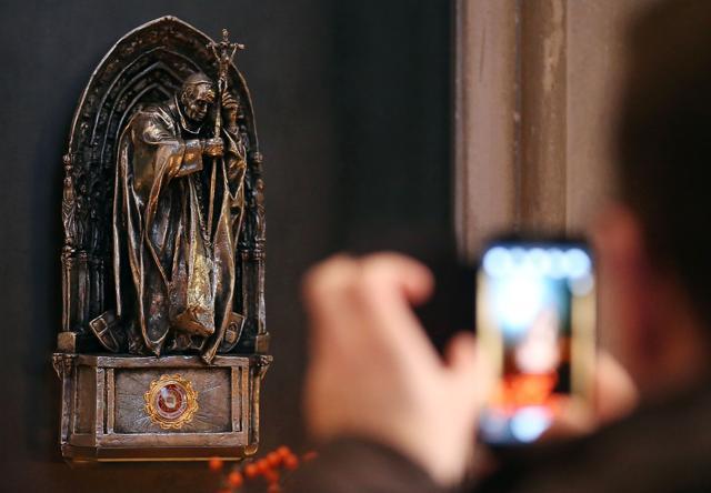 A tourist photographing a statue containing the relic of Pope John Paul II in the Cologne cathedral, western Germany. (AFP file photo)
