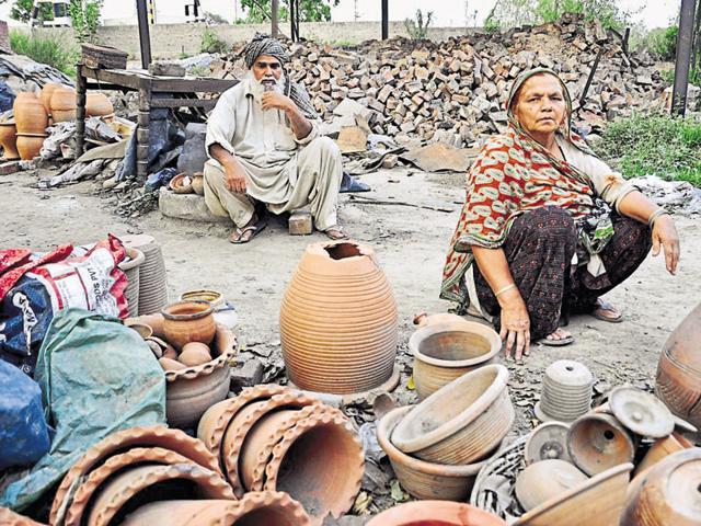 Potters watch helplessly in Manimajra on Friday.(Sant Arora/HT Photo)