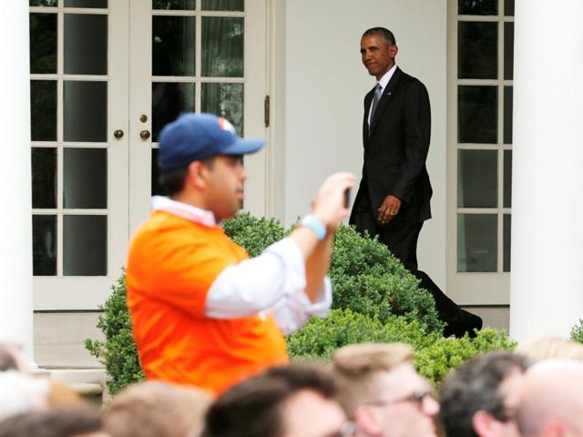A Denver Broncos fan takes pictures of the team as US President Barack Obama walks back to the Oval Office (rear) after welcoming the Broncos for a reception in honor of their NFL Super Bowl football championship, in the Rose Garden of the White House in Washington. (REUTERS) A Denver Broncos fan takes pictures of the team as US President Barack Obama walks back to the Oval Office (rear) after welcoming the Broncos for a reception in honor of their NFL Super Bowl football championship, in the Rose Garden of the White House in Washington. (REUTERS)