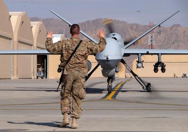 A US airman guides a US Air Force MQ-9 Reaper drone as it taxis to the runway at Kandahar Airfield, Afghanistan March 9, 2016.