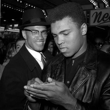 In this file photo, Muhammad Ali is shown with Malcolm X, a senior member of the Nation of Islam, outside the Trans-Lux Newsreel Theater in New York City. (AP) In this file photo, Muhammad Ali is shown with Malcolm X, a senior member of the Nation of Islam, outside the Trans-Lux Newsreel Theater in New York City. (AP)