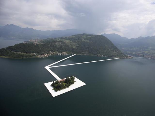 An aerial view of the in-progress installation, The Floating Piers, on the Lake Iseo in northern Italy. It is a 3-km runway connecting the town of Sulzano to the small island of Monte Isola, created using 2,20,000 floating polyethylene cubes attached together to form a modular floating dock system. (AP)