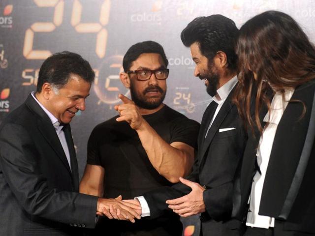Sonam Kapoor looks on as actors Amir Khan and Anil Kapoor speak with Colors CEO Raj Nayak during the trailer launch of 24 Season 2. (AFP)