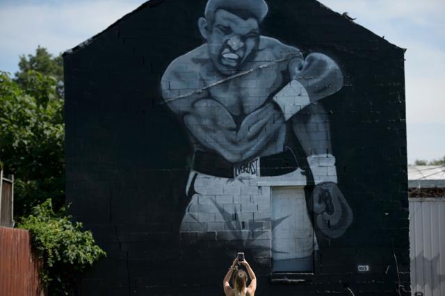 A woman photographs a mural of Muhammad Ali's 1965 victory over Sonny Liston in Louisville. (AFP Photo) A woman photographs a mural of Muhammad Ali's 1965 victory over Sonny Liston in Louisville. (AFP Photo)