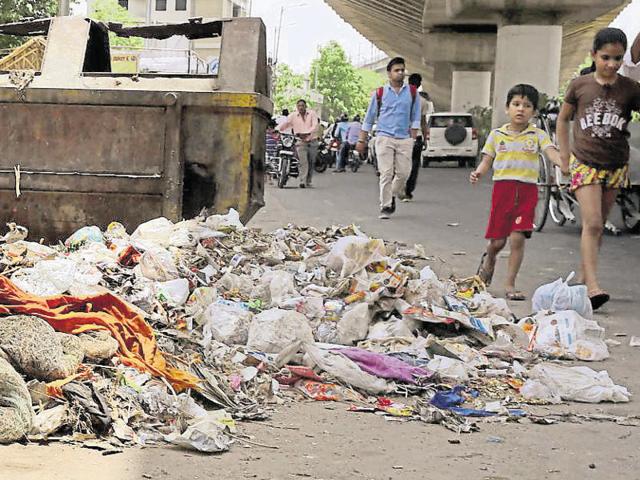 A man covers his nose as he crosses MI Road littered with waste. (Himanshu Vyas/HT Photo) A man covers his nose as he crosses MI Road littered with waste. (Himanshu Vyas/HT Photo)