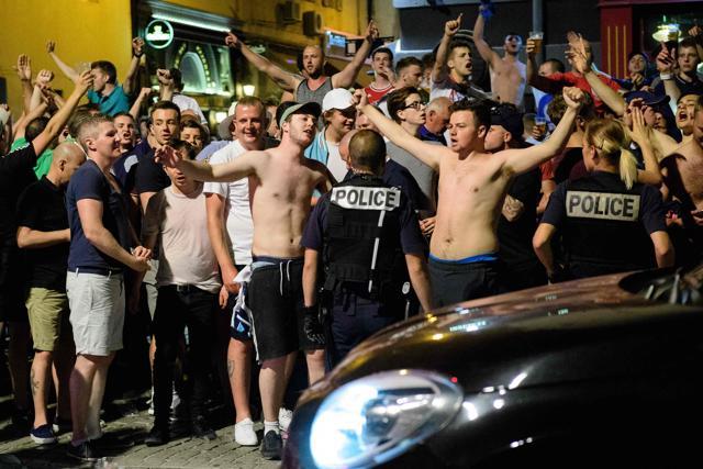 Police stand guard as England fans gather and chant slogans in the port area of Marseille, ahead of the start of the Euro 2016 football tournament in France. (AFP Photo) Police stand guard as England fans gather and chant slogans in the port area of Marseille, ahead of the start of the Euro 2016 football tournament in France. (AFP Photo)