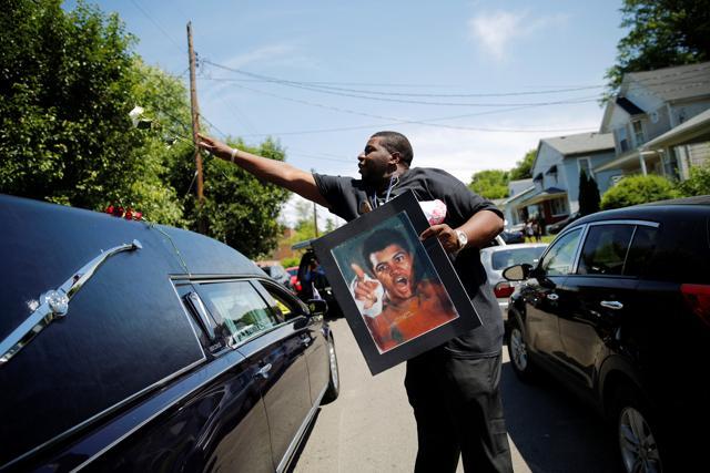 A man throws a rose over the hearse carrying the remains of Muhammad Ali during the funeral procession for the three-time heavyweight boxing champion in Louisville, Kentucky. (Reuters Photo) A man throws a rose over the hearse carrying the remains of Muhammad Ali during the funeral procession for the three-time heavyweight boxing champion in Louisville, Kentucky. (Reuters Photo)