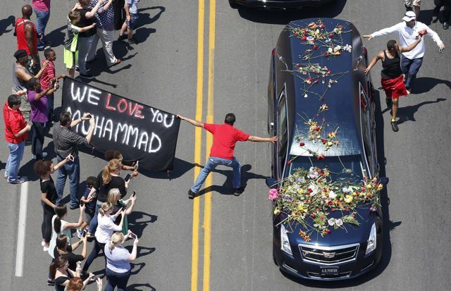 A well-wisher holding a banner touches the hearse carrying the remains of Muhammad Ali during the funeral procession for the three-time heavyweight boxing champion. (Reuters Photo) A well-wisher holding a banner touches the hearse carrying the remains of Muhammad Ali during the funeral procession for the three-time heavyweight boxing champion. (Reuters Photo)