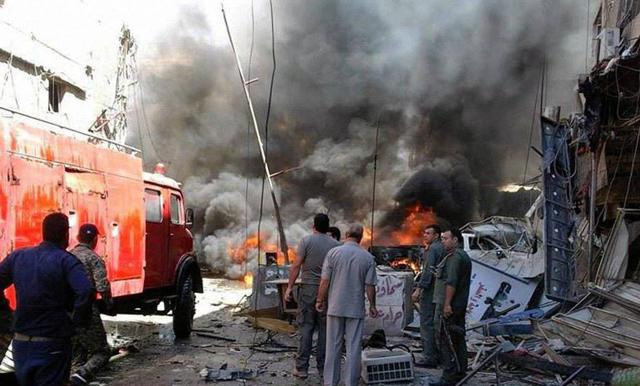 Syrians gather around burning buildings after a bomb attack at the Sayeda Zeinab suburb in Damascus, Syria on Saturday. (AP) Syrians gather around burning buildings after a bomb attack at the Sayeda Zeinab suburb in Damascus, Syria on Saturday. (AP)