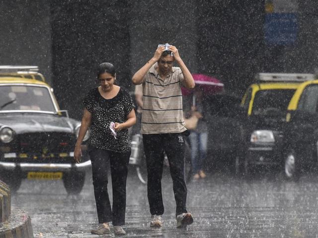 People enjoy the walk in the rain at Matunga in Mumbai on Saturday. Mumbai experienced its first rain today after a very hot and humid week. (Kunal Patil)