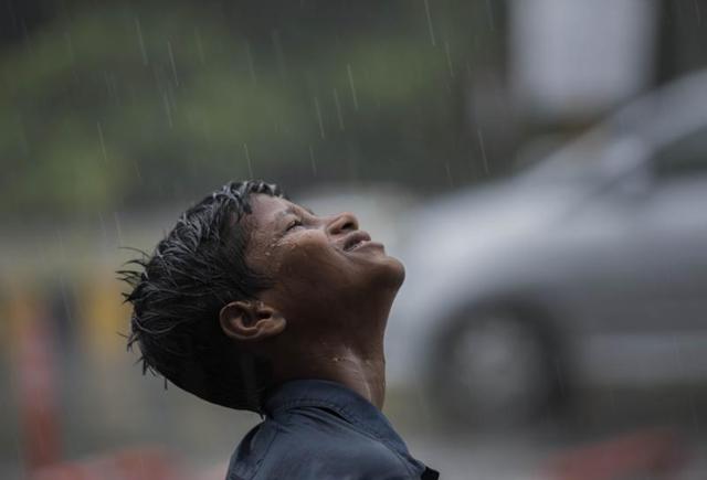A boy enjoys raindrops at Vileparle in Mumbai on Saturday. Mumbai experienced its first rain today after a very hot and humid week. (Satish Bate)
