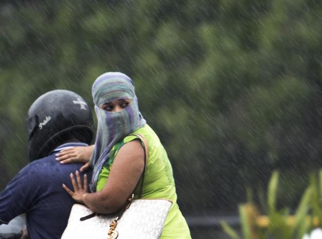 A couple enjoys ride in the rain on western express highway in Mumbai on Saturday. Mumbai experienced its first rain today after a very hot and humid week. (Satish Bate)