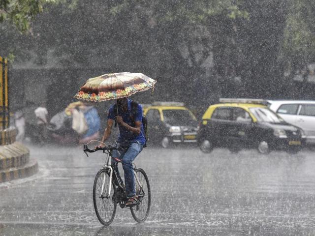 A man holding umbrella on a bicycle during the rain at Matunga in Mumbai, India, on Saturday, June 11, 2016. (Photo by Kunal Patil/ Hindustan Times) (Kunal Patil)