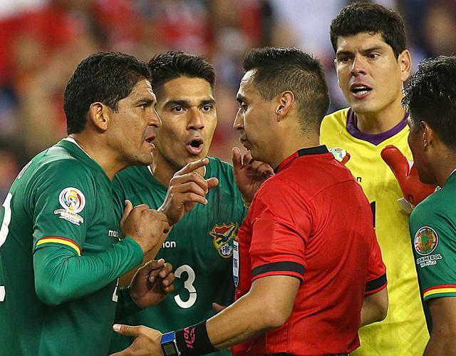 Edward Zenteno, left, of Bolivia and Luis Gutierrez #3 argue with the referee over the call of handball. (AFP) Edward Zenteno, left, of Bolivia and Luis Gutierrez #3 argue with the referee over the call of handball. (AFP)