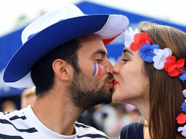 A man and a woman supporting France kiss prior to the Euro 2016 group A football match between France and Romania at Stade de France, in Saint-Denis. (AFP)
