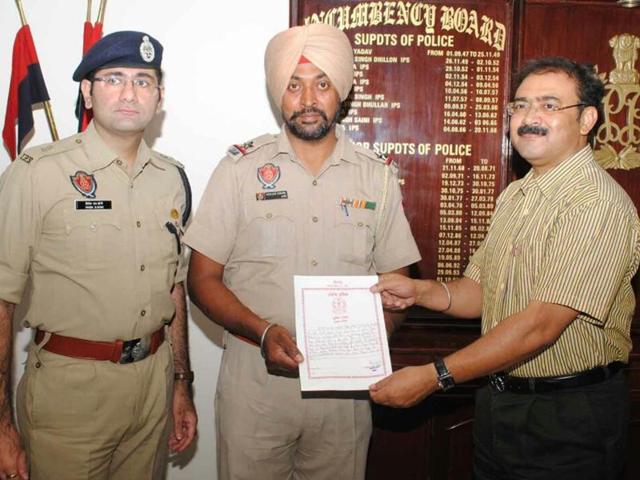 Commisioner of police Arpit Shukla honouring assistant sub-inspector Mohan Singh in Jalandhar on Saturday.(HT Photo) Commisioner of police Arpit Shukla honouring assistant sub-inspector Mohan Singh in Jalandhar on Saturday.(HT Photo)