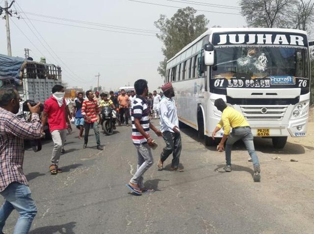 People throwing stones at the bus on Monday. (HT Photo) People throwing stones at the bus on Monday. (HT Photo)