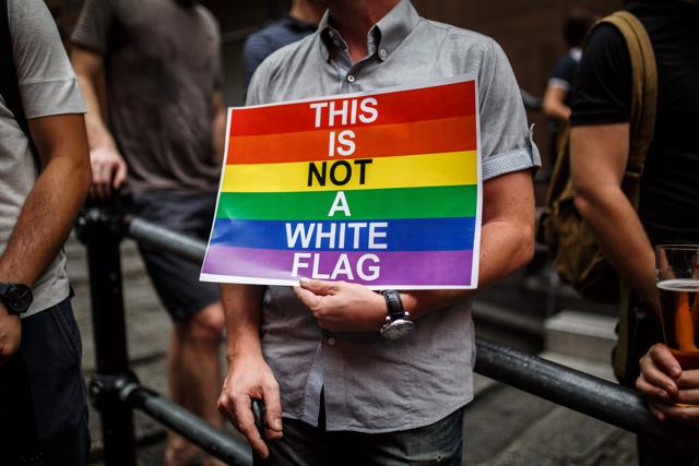 A man holds a poster as he attends a vigil for the victims of the Orlando shooting in Florida, in Hong Kong on June 13, 2016. (AFP)