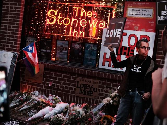Mourners gather outside the iconic New York City gay and lesbian bar The Stonewall Inn to light candles,lay flowers and grieve for those killed in Orlando on June 12, 2016 in New York City. (AFP Photo)