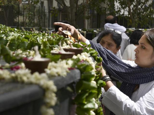 A woman lights a diya at Smriti Upvan. (Saumya Khandelwal/HT Photo)