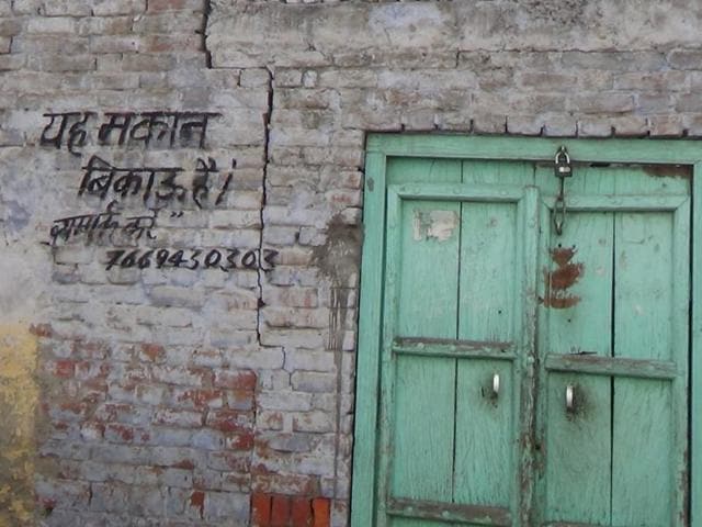 Varun Kumar with his police security at his shop in main bazar, Kairana. His brother's day light murder in August 2014 by Mukheem Kala brought Kairana's crime into limelight.(Virendra Singh Gosain / HT Photo)