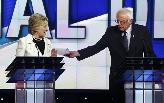 Clinton reacts as rival candidate Senator Bernie Sanders tries to hand her a piece of paper during a Democratic debate hosted by CNN and New York One in New York on April 14, 2016. (Reuterws file photo) Clinton reacts as rival candidate Senator Bernie Sanders tries to hand her a piece of paper during a Democratic debate hosted by CNN and New York One in New York on April 14, 2016. (Reuterws file photo)