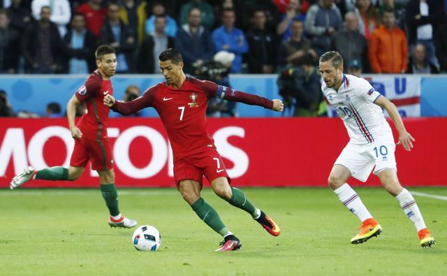 Portugal's forward Cristiano Ronaldo (C) vies for the ball with Iceland's midfielder Gylfi Sigurdsson. (AFP) Portugal's forward Cristiano Ronaldo (C) vies for the ball with Iceland's midfielder Gylfi Sigurdsson. (AFP)