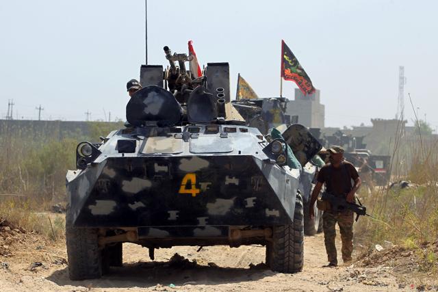 A member of Iraqi government forces walks next to an armoured vehicle during an operation, backed by air support from the US-led coalition, in Fallujah's southern Shuhada neighbourhood to retake the area from the Islamic State (IS) group on June 15, 2016. (AFP) A member of Iraqi government forces walks next to an armoured vehicle during an operation, backed by air support from the US-led coalition, in Fallujah's southern Shuhada neighbourhood to retake the area from the Islamic State (IS) group on June 15, 2016. (AFP)