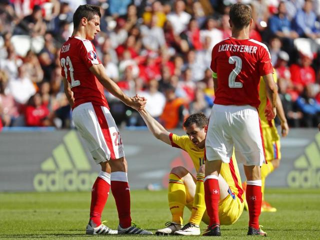 Romania's Andrei Prepelita is helped to his feet by Switzerland's Fabian Schar and Stephan Lichtsteiner. (Reuters Photo) Romania's Andrei Prepelita is helped to his feet by Switzerland's Fabian Schar and Stephan Lichtsteiner. (Reuters Photo)