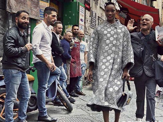 One picture sees the female models walk bashfully though a cheering crowd, but all feature locals going about their daily business, exiting restaurants, selling chocolate and admiring pretty girls. (Dolce & Gabbana) 
