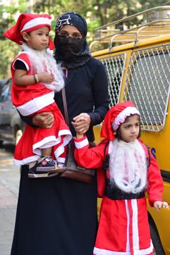 A photo from Vikas Khanna’s book Utsav shows a Muslim woman with her children dressed as Santa Claus. (HT Photo) A photo from Vikas Khanna’s book Utsav shows a Muslim woman with her children dressed as Santa Claus. (HT Photo)